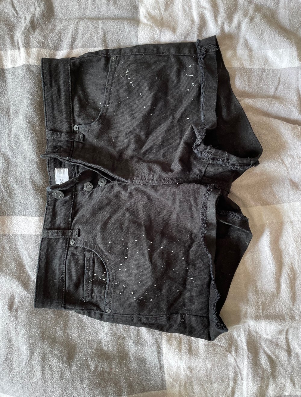 schwarze Short mit weißen Effekten